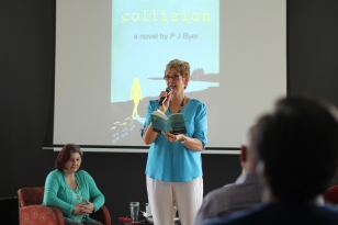 PJ reading an extract from Collision, in background Tima Maria Lacoba author interviewer
